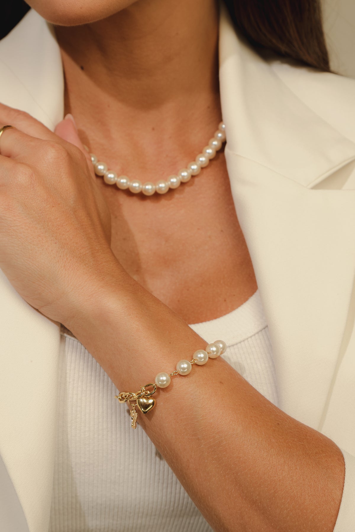 Pulseira Corrente e Pérolas com Pingente de Coração Dourada combinada com outras peças